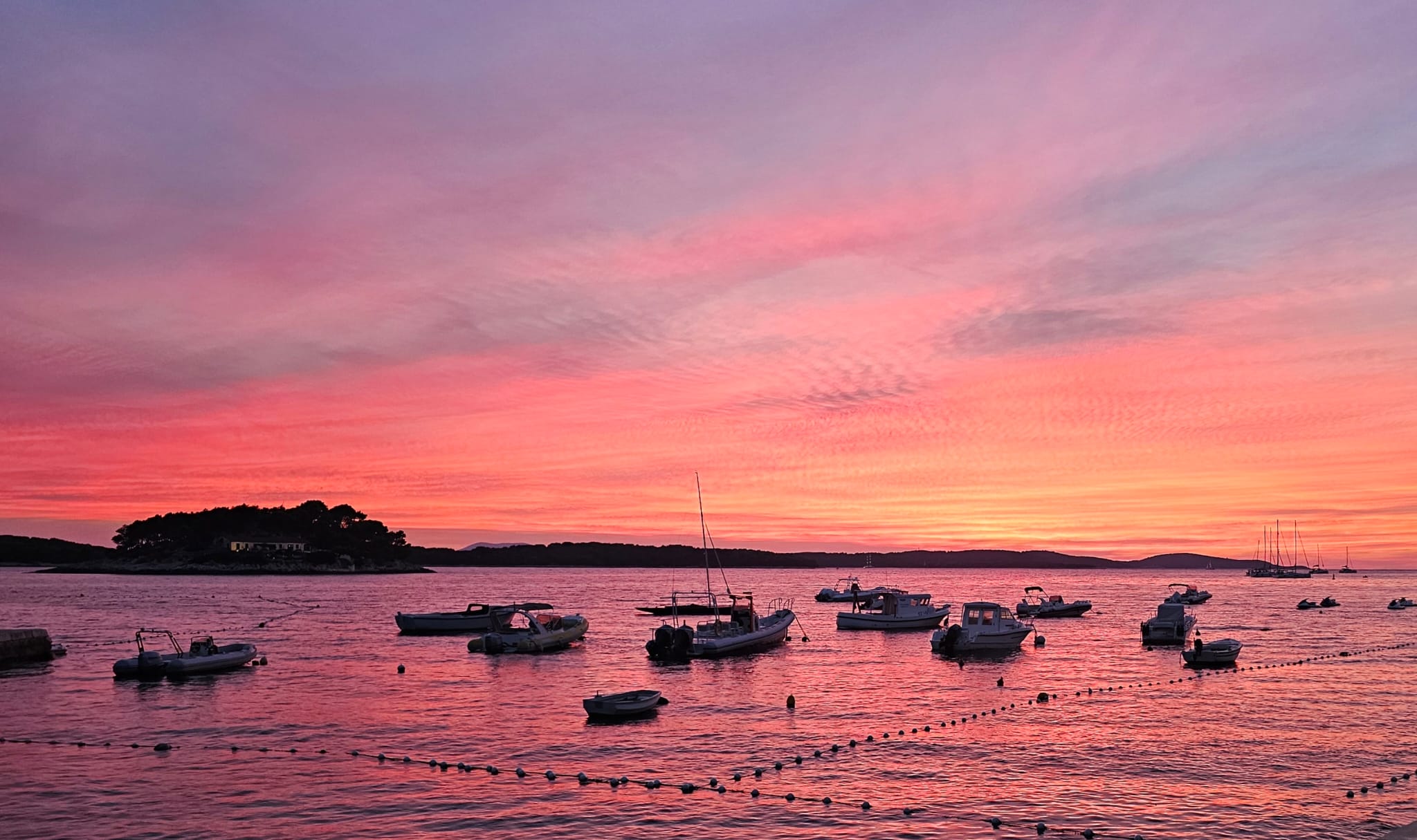 Pink sunset sky over boats anchored near Hvar