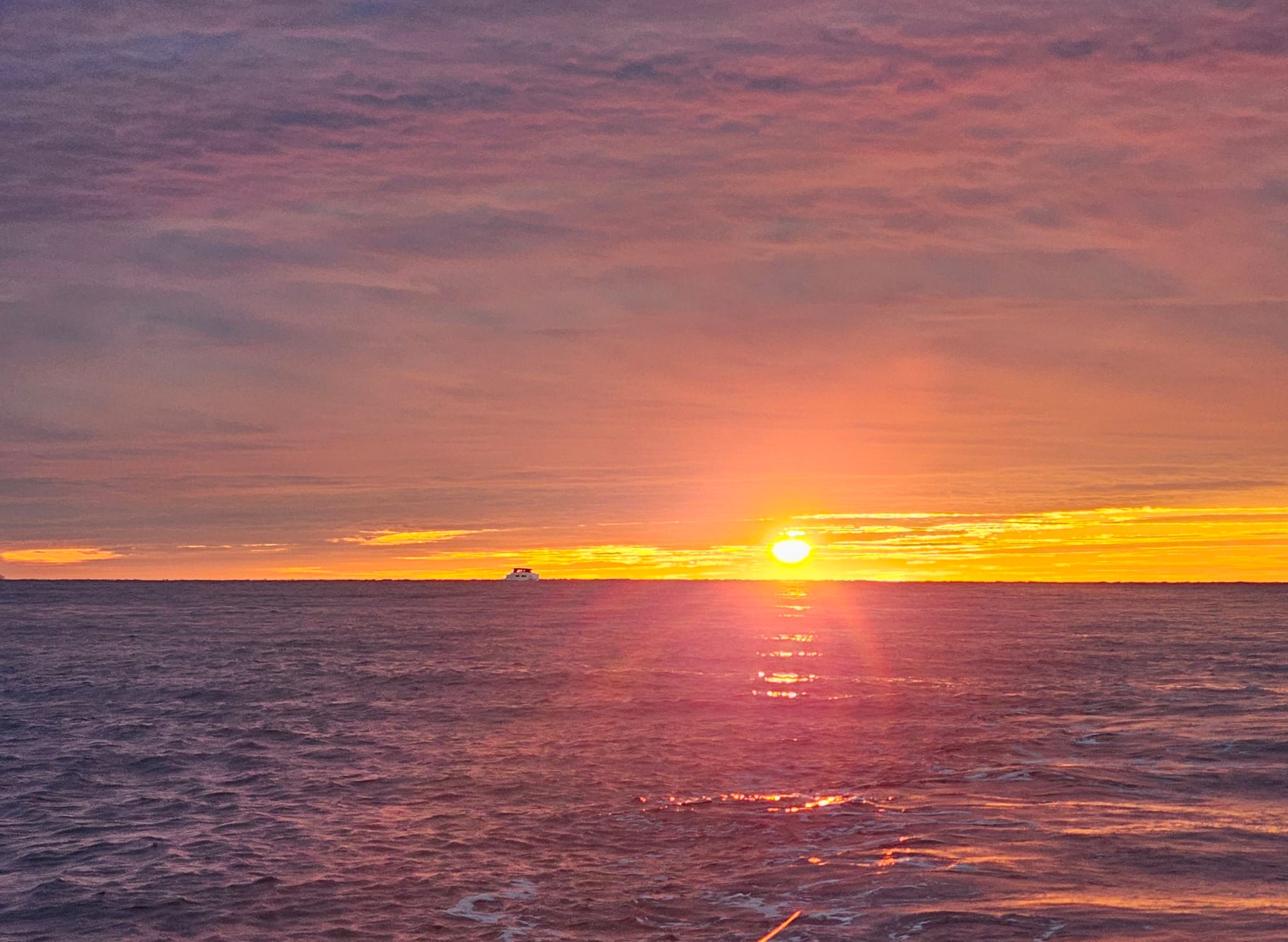 The sun touching the horizon over the open sea